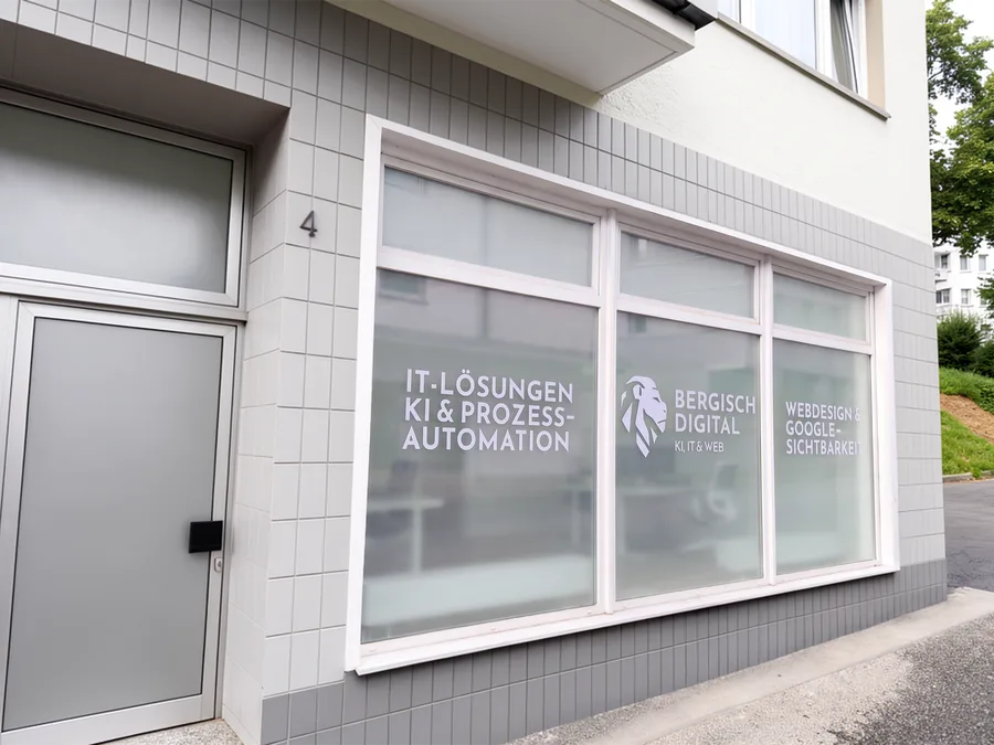 Schaufenster des Büros Kremenhollerstr. 4 in Remscheid mit der Beschriftung „IT-Lösungen, KI und Prozessautomation“, dem Bergisch-Digital-Logo und „Webdesign und Google-Sichtbarkeit“.